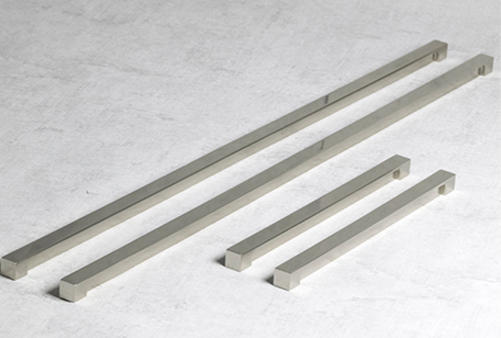 Image of four custom cabinet handle with a reduced projection. The cabinet handles are finished in a satin nickel.