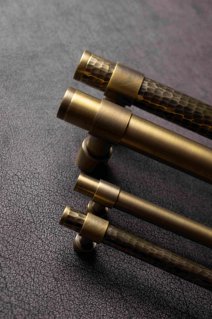 Shown in a Fine Antique Brass finish and Burnished Brass for the hammered pulls, are the latest Stepped pull handles from Turnstyle Designs. Both Solid brass and hand hammered pull handles are shown alongside the matching cabinet pulls.
