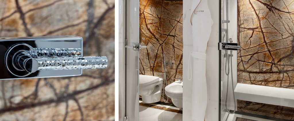 Luxury hand hammered door lever on glass bathroom door in Bright Chrome.