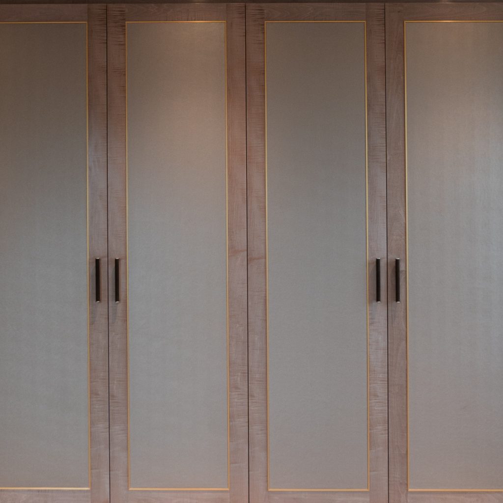 A large double cupboard in a neo-Georgian style kitchen. All four doors are closed showing off the hand made, hand crafted Shagreen amalfine scroll handles by Turnstyle Designs.