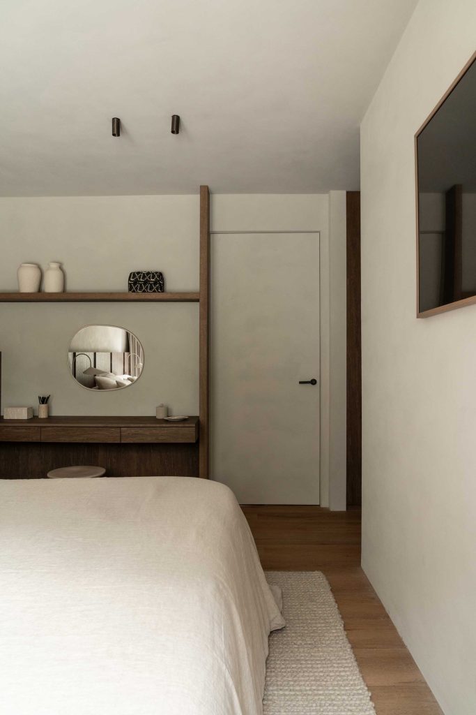 A neutral off white bedroom in a luxury family residence. Soft furnishings work alongside bespoke wooden furniture warm the calmer colours.