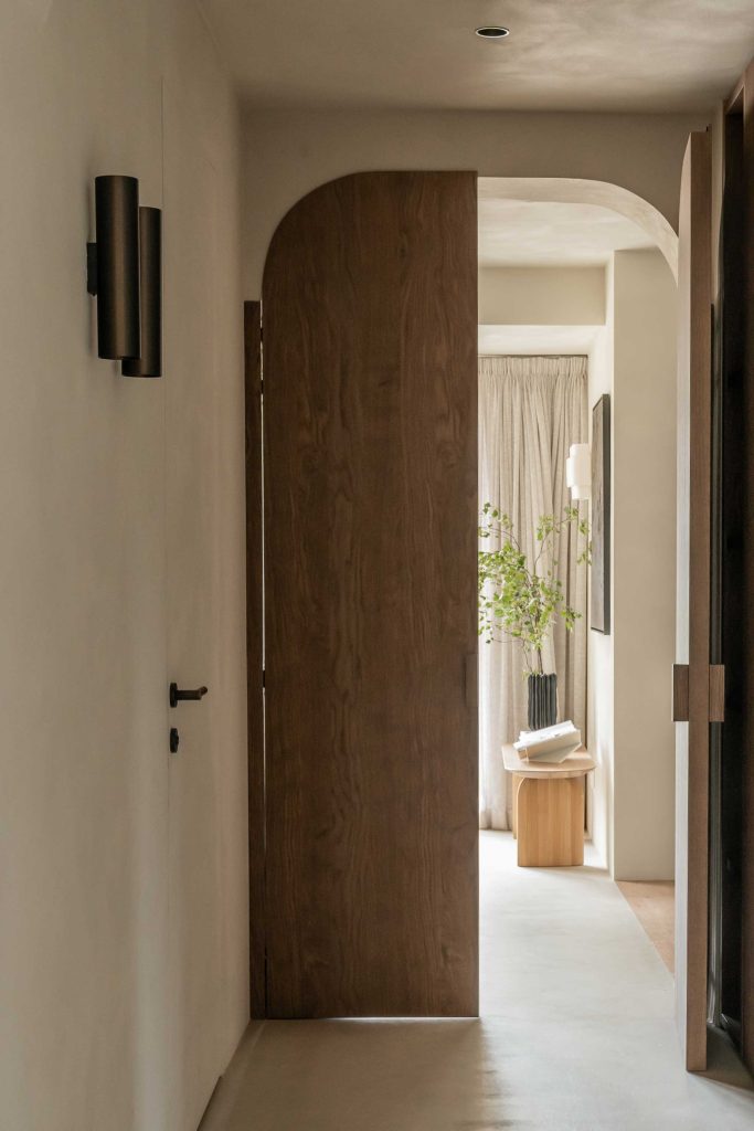 Bespoke curved doors arches and natural wooden doors have been used in this minimalistic calming interior. Solid brass door levers by Turnstyle Designs have been used alongside.