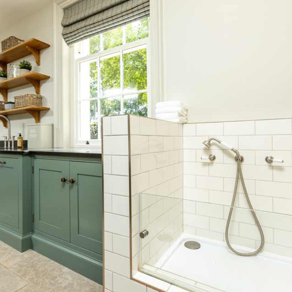 Luxury bespoke dog shower unit built in to this spacious utility room. Tiled with modern white tiles and finished with half glass section.